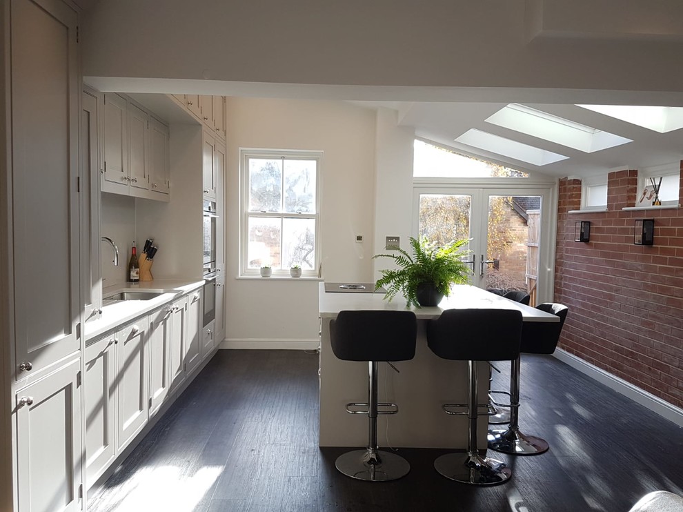 Offene, Mittelgroße Klassische Küche mit Schrankfronten im Shaker-Stil, grauen Schränken, Kücheninsel und schwarzem Boden in Hertfordshire