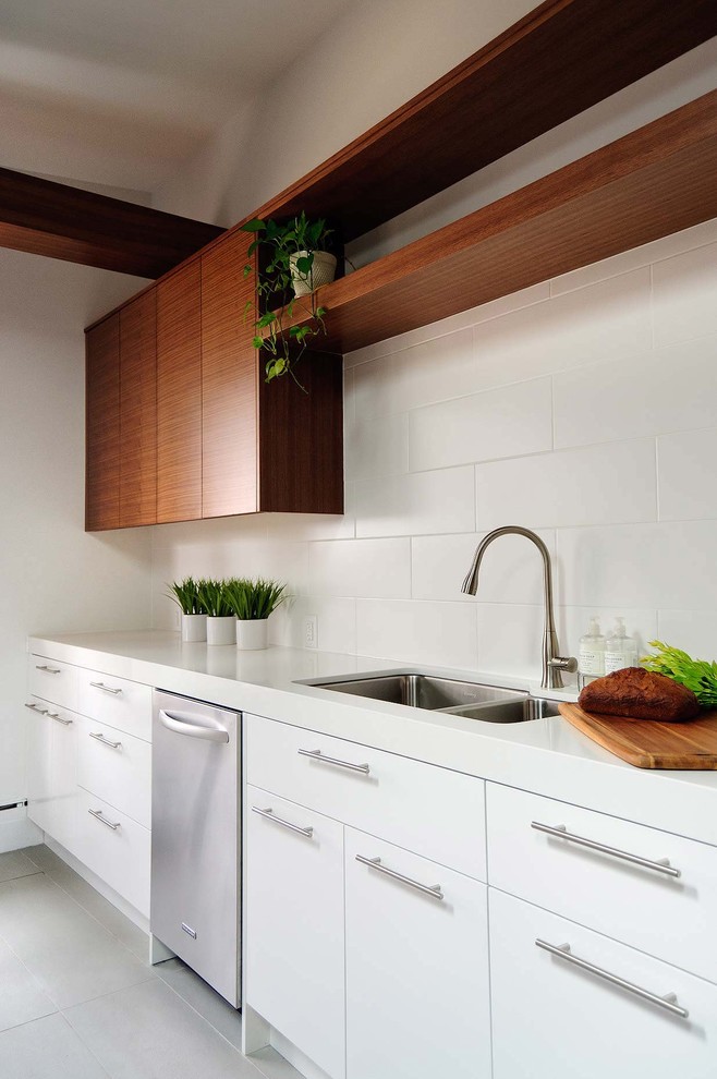 Moderne Küche mit Küchengeräten aus Edelstahl, Doppelwaschbecken, flächenbündigen Schrankfronten, weißen Schränken und Küchenrückwand in Weiß in Toronto