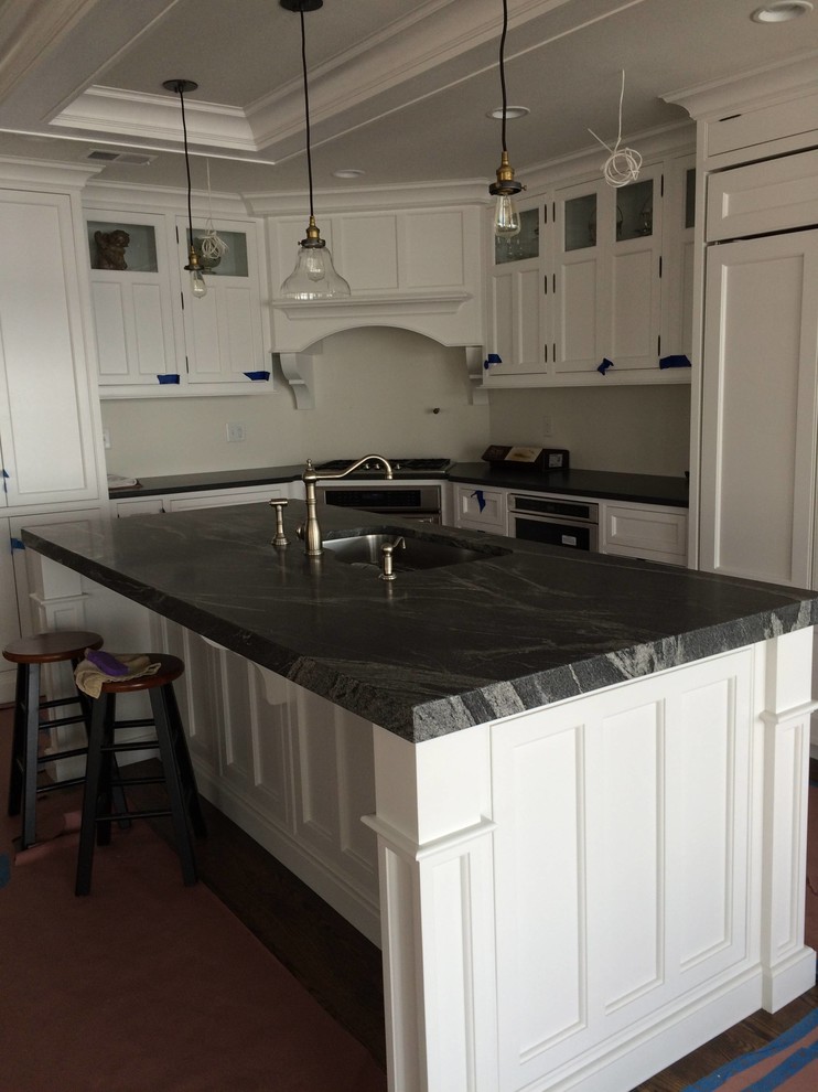 Aménagement d'une cuisine américaine classique avec un plan de travail en granite et îlot.