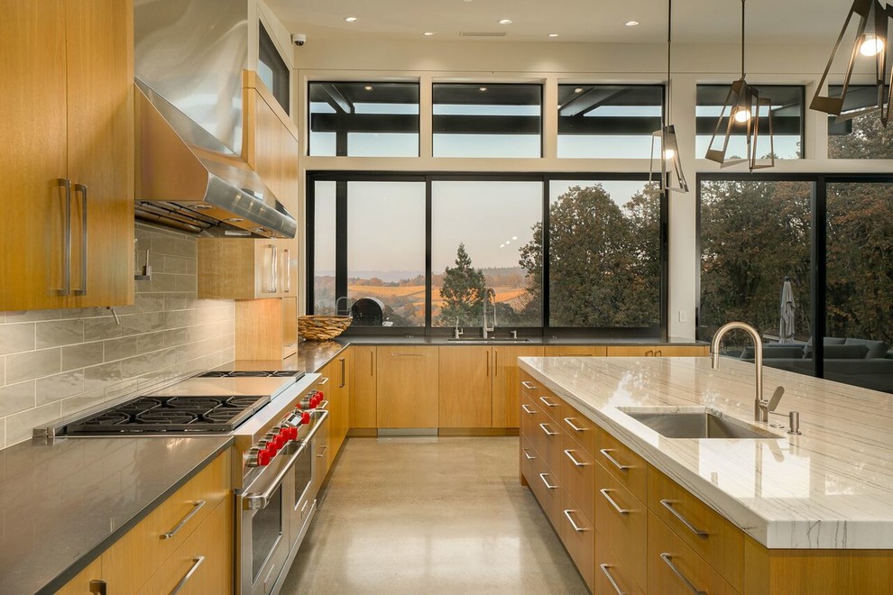 Exempel på ett modernt grå grått l-kök, med en undermonterad diskho, släta luckor, skåp i mellenmörkt trä, grått stänkskydd, stänkskydd i tunnelbanekakel, rostfria vitvaror, betonggolv, en köksö och grått golv