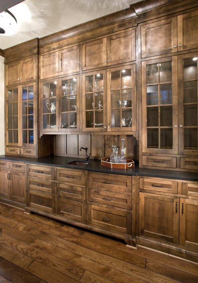 Idée de décoration pour une cuisine chalet en bois foncé avec un placard à porte vitrée.