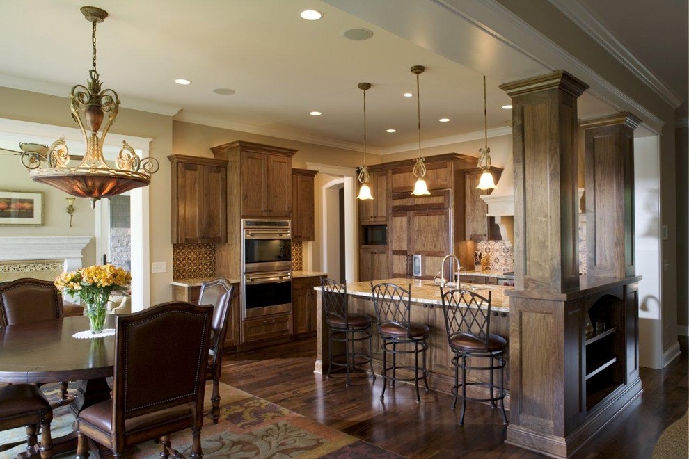 Diseño de cocina comedor clásica con electrodomésticos con paneles, armarios con paneles empotrados, puertas de armario de madera oscura y salpicadero marrón
