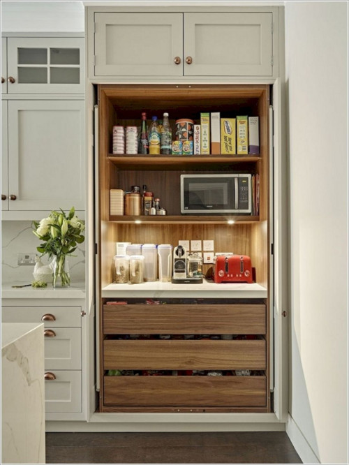 Organized kitchen cabinet pantry with microwave, toaster, and pull-out drawers—illustrating safe weight limits and smart storage for Canadian cabinets