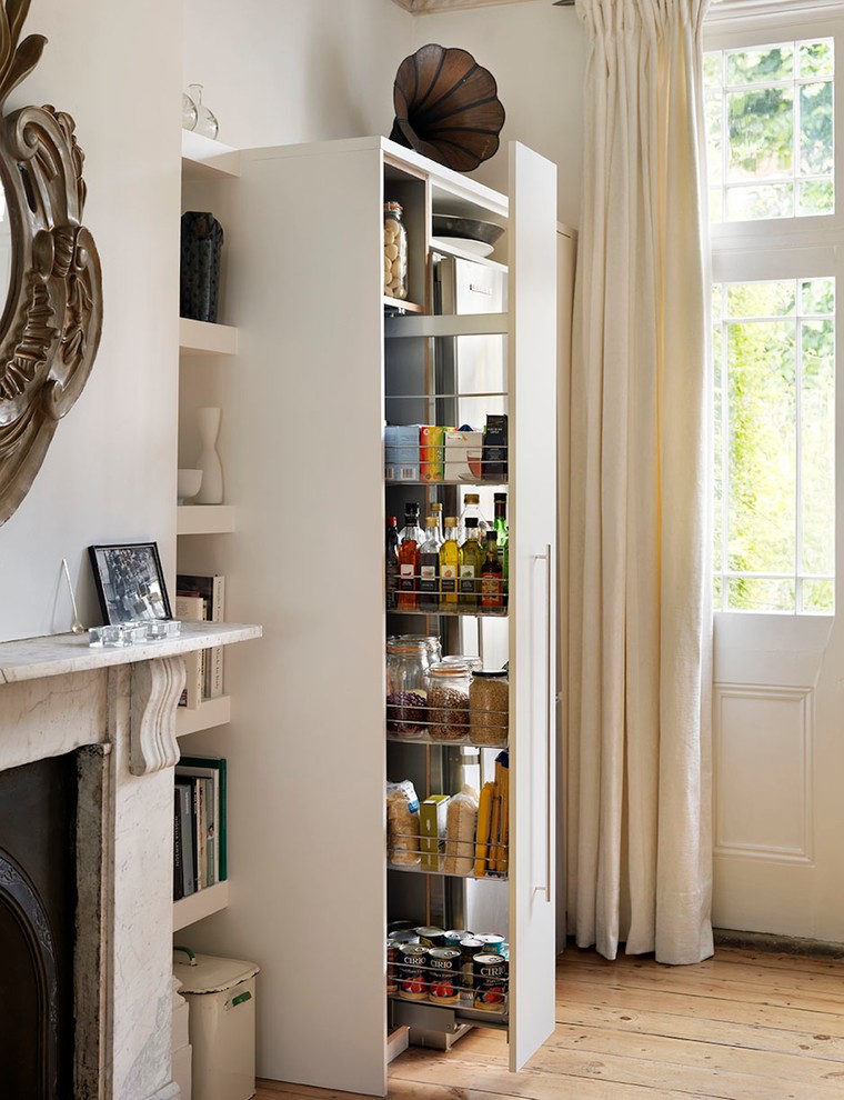 This is an example of a large contemporary kitchen pantry in London with flat-panel cabinets and white cabinets.
