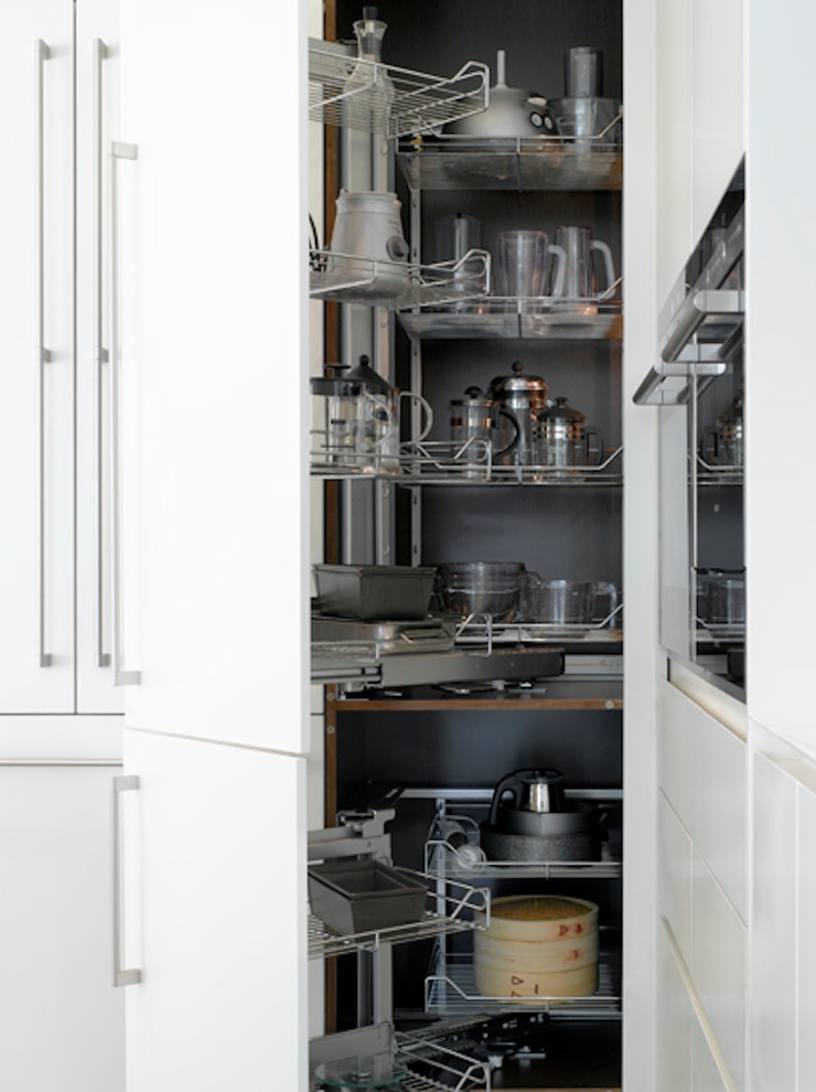 Photo of a large contemporary open plan kitchen in London with flat-panel cabinets and white cabinets.