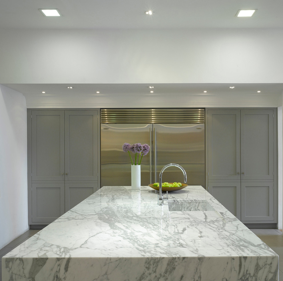 Photo of a large contemporary open plan kitchen in London with an integrated sink, recessed-panel cabinets, grey cabinets, marble worktops, stainless steel appliances and an island.