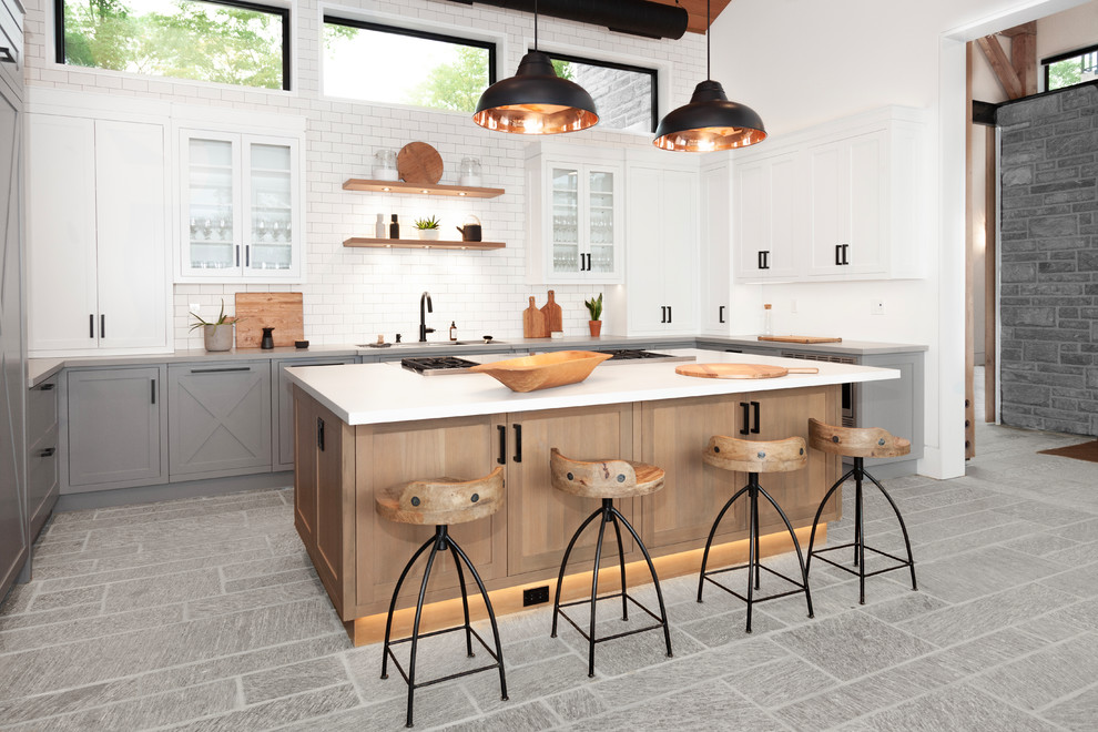 Inspiration for a farmhouse u-shaped gray floor kitchen remodel in Toronto with an undermount sink, glass-front cabinets, white cabinets, white backsplash, subway tile backsplash, an island and gray countertops