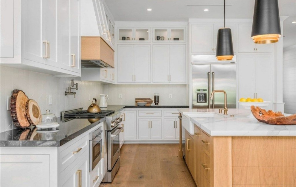 Inspiration for a large modern light wood floor and brown floor eat-in kitchen remodel in Los Angeles with a farmhouse sink, flat-panel cabinets, white cabinets, quartzite countertops, white backsplash, glass tile backsplash, stainless steel appliances, an island and white countertops