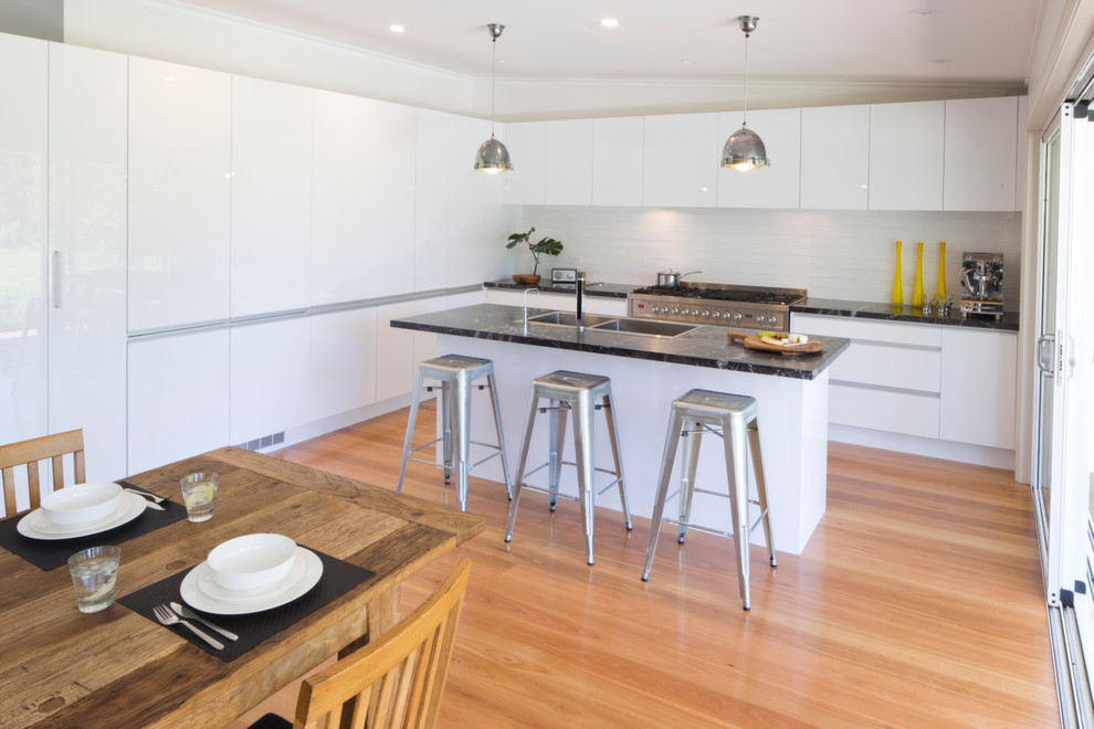 Inspiration for a medium sized urban kitchen/diner in Sydney with flat-panel cabinets, white splashback, metro tiled splashback and an island.