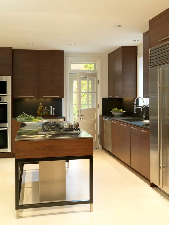 Photo of a large modern l-shaped enclosed kitchen in Chicago with a submerged sink, flat-panel cabinets, dark wood cabinets, stainless steel worktops, black splashback, stone slab splashback, stainless steel appliances, porcelain flooring, an island, beige floors and grey worktops.