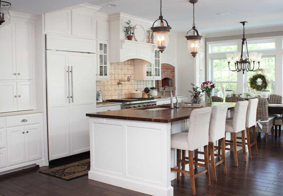 Eat-in kitchen - large traditional galley dark wood floor eat-in kitchen idea in Wilmington with an undermount sink, shaker cabinets, yellow cabinets, quartzite countertops, beige backsplash, terra-cotta backsplash, paneled appliances and an island