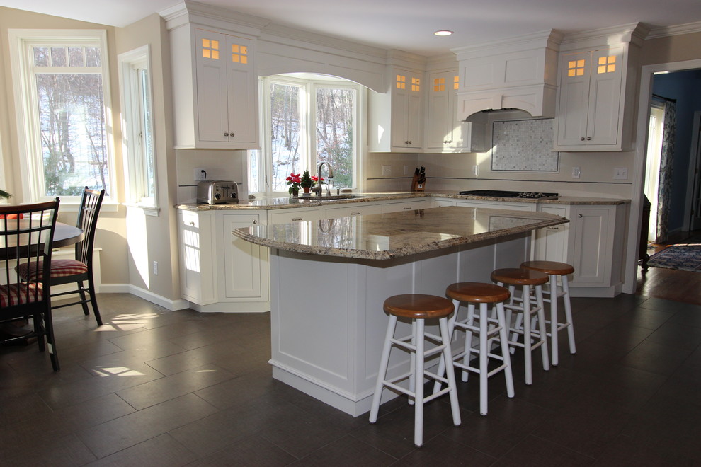 Kitchen - large traditional porcelain tile kitchen idea in Boston with an undermount sink, recessed-panel cabinets, white cabinets, granite countertops, white backsplash, subway tile backsplash, paneled appliances and an island