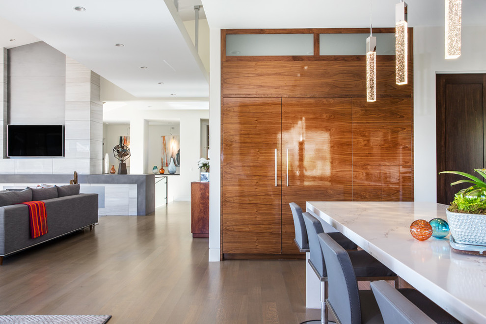 Example of a mid-sized trendy u-shaped light wood floor and beige floor eat-in kitchen design in Salt Lake City with flat-panel cabinets, brown cabinets, paneled appliances, an island, a drop-in sink, quartzite countertops, white backsplash, subway tile backsplash and white countertops