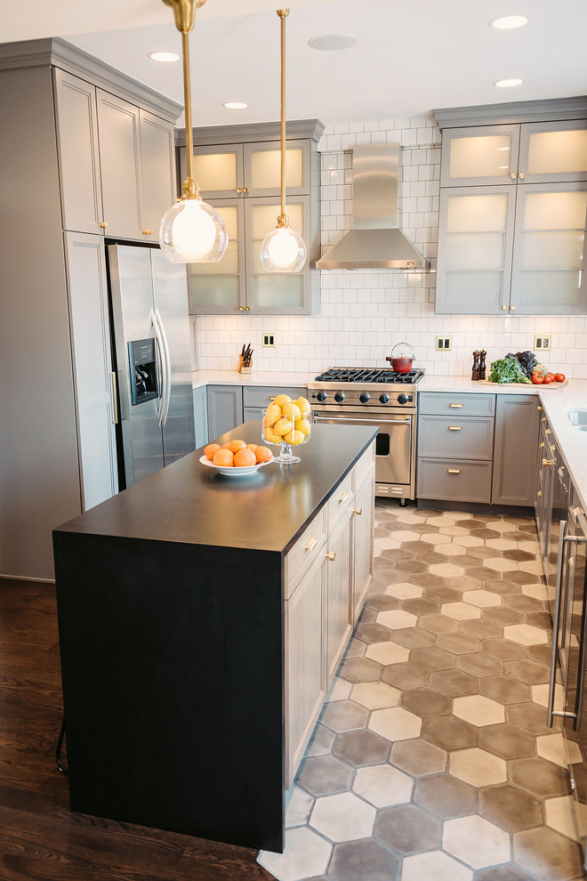 Exempel på ett stort modernt kök, med en dubbel diskho, luckor med upphöjd panel, bruna skåp, marmorbänkskiva, vitt stänkskydd, stänkskydd i keramik, rostfria vitvaror, cementgolv, en köksö och grått golv