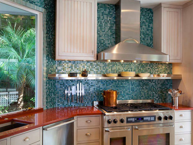 Diseño de cocina contemporánea de tamaño medio sin isla con fregadero bajoencimera, puertas de armario blancas, encimera de acrílico, salpicadero azul, salpicadero de azulejos de vidrio, electrodomésticos de acero inoxidable y encimeras rojas