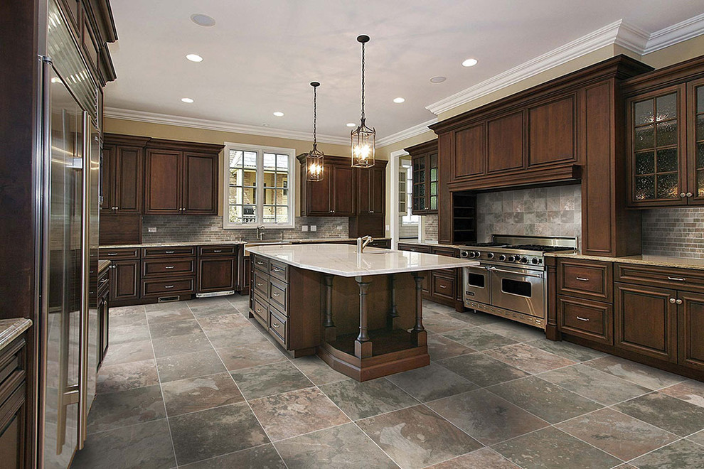 Exempel på ett stort klassiskt l-kök, med en undermonterad diskho, luckor med upphöjd panel, skåp i mörkt trä, brunt stänkskydd, stänkskydd i stenkakel, rostfria vitvaror, en köksö och flerfärgat golv