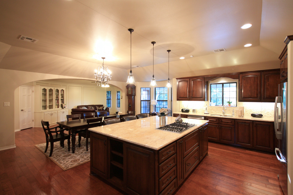 Inspiration for a mid-sized timeless l-shaped medium tone wood floor eat-in kitchen remodel in Austin with an undermount sink, raised-panel cabinets, medium tone wood cabinets, white backsplash, stone tile backsplash, white appliances and an island