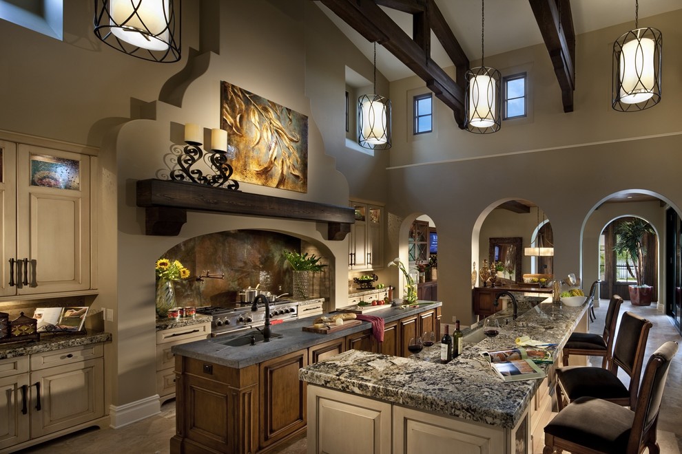 Mediterranean galley kitchen in Other with a submerged sink, raised-panel cabinets, beige cabinets, beige splashback, stainless steel appliances and multiple islands.
