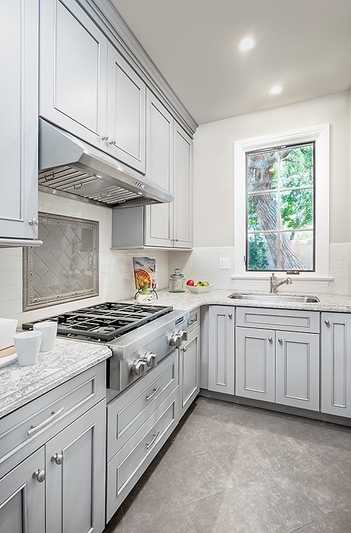 Eat-in kitchen - mid-sized traditional u-shaped dark wood floor eat-in kitchen idea in Los Angeles with a double-bowl sink, recessed-panel cabinets, gray cabinets, granite countertops, white backsplash, subway tile backsplash, stainless steel appliances and an island