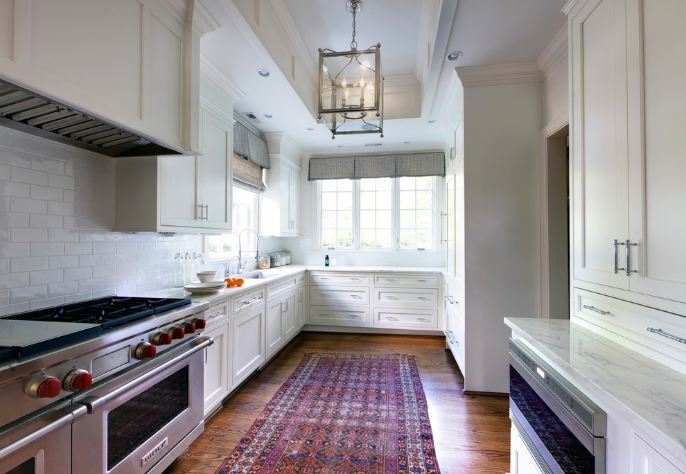 Enclosed kitchen - transitional u-shaped enclosed kitchen idea in Charlotte with stainless steel appliances, an undermount sink, recessed-panel cabinets, white cabinets, white backsplash and subway tile backsplash