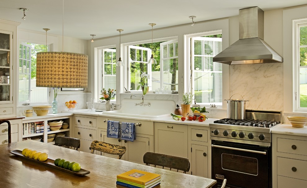 Inspiration for a timeless eat-in kitchen remodel in Burlington with a drop-in sink, beaded inset cabinets, marble countertops, white backsplash, stone slab backsplash, black appliances and beige cabinets