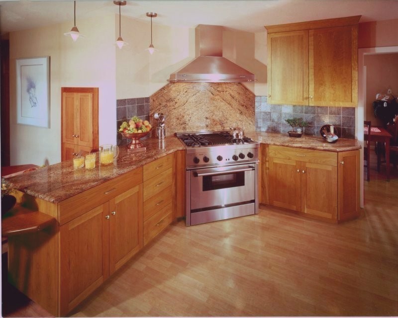 Foto på ett mellanstort eklektiskt kök, med en undermonterad diskho, skåp i shakerstil, skåp i mellenmörkt trä, granitbänkskiva, stänkskydd med metallisk yta, stänkskydd i stenkakel, rostfria vitvaror och en halv köksö