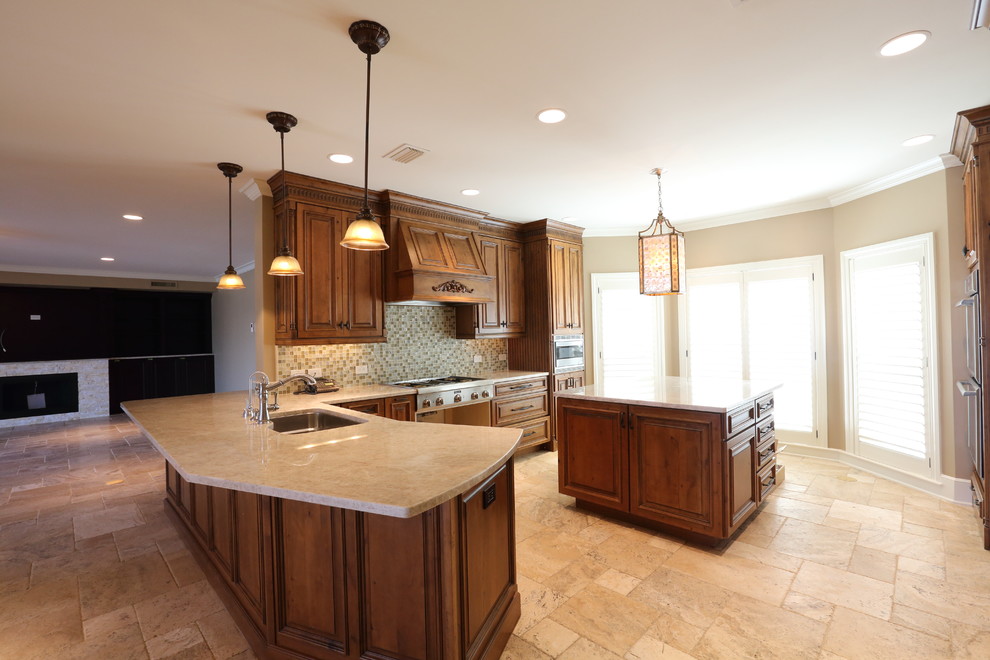 Large tuscan u-shaped limestone floor eat-in kitchen photo in Tampa with a single-bowl sink, raised-panel cabinets, medium tone wood cabinets, granite countertops, multicolored backsplash, mosaic tile backsplash, stainless steel appliances and an island