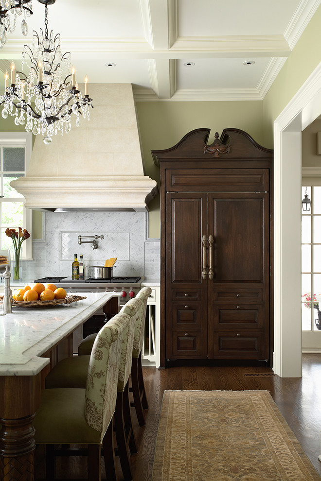 Foto di una cucina classica con ante con bugna sagomata, ante in legno bruno, paraspruzzi bianco, elettrodomestici da incasso, paraspruzzi in marmo e struttura in muratura