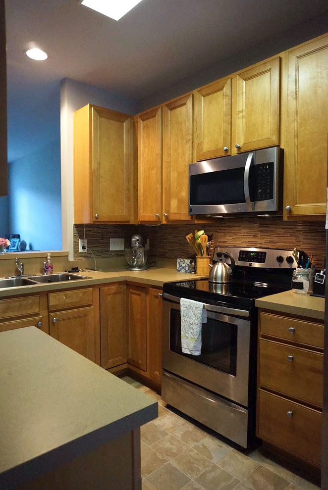Foto de cocinas en L clásica de tamaño medio con armarios con paneles empotrados, electrodomésticos de acero inoxidable y una isla