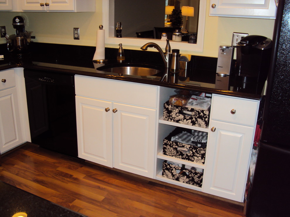 Example of a classic u-shaped eat-in kitchen design in DC Metro with an undermount sink, raised-panel cabinets and white cabinets