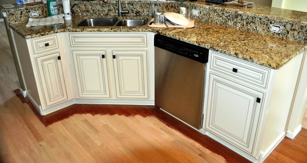 Moderne Wohnküche in L-Form mit Unterbauwaschbecken, weißen Schränken, Granit-Arbeitsplatte, Küchengeräten aus Edelstahl und Kücheninsel in Charleston