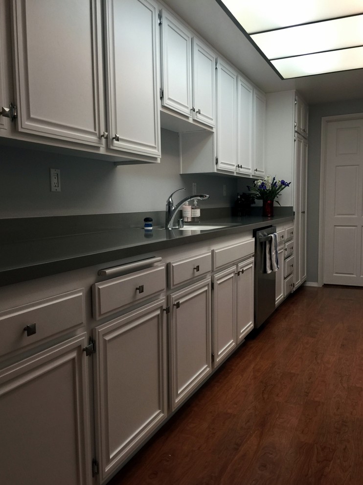 Idéer för att renovera ett mellanstort funkis kök, med en undermonterad diskho, luckor med infälld panel, vita skåp, bänkskiva i kvarts, rostfria vitvaror, linoleumgolv och brunt golv