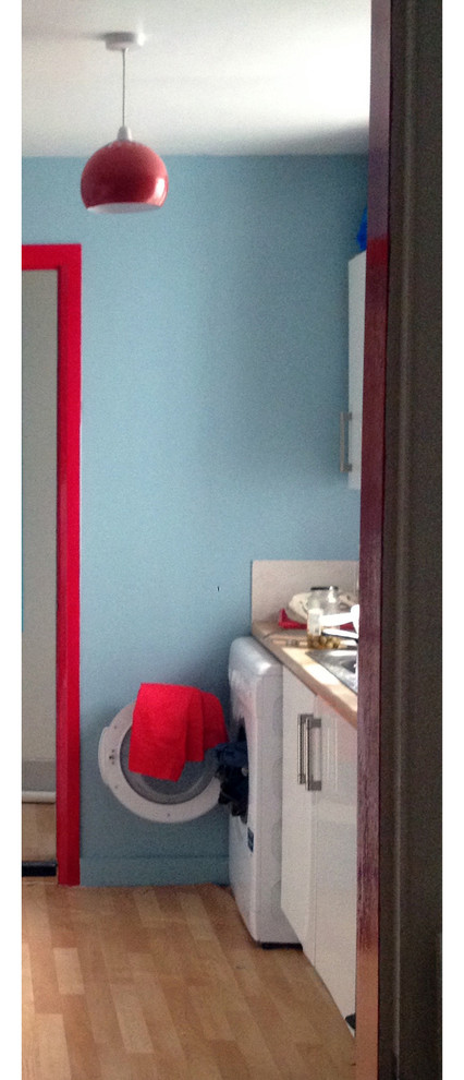 Imagen de cocina ecléctica de tamaño medio cerrada sin isla con armarios con paneles lisos, puertas de armario blancas, encimera de laminado, salpicadero rojo, electrodomésticos blancos y suelo vinílico