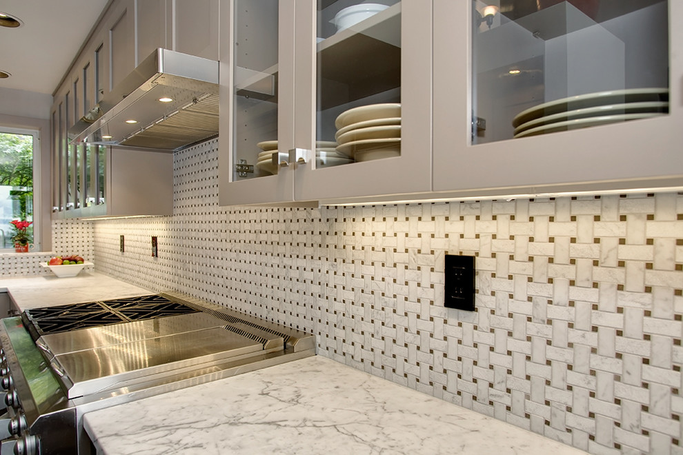 Foto på ett funkis kök, med grå skåp, marmorbänkskiva, vitt stänkskydd och rostfria vitvaror