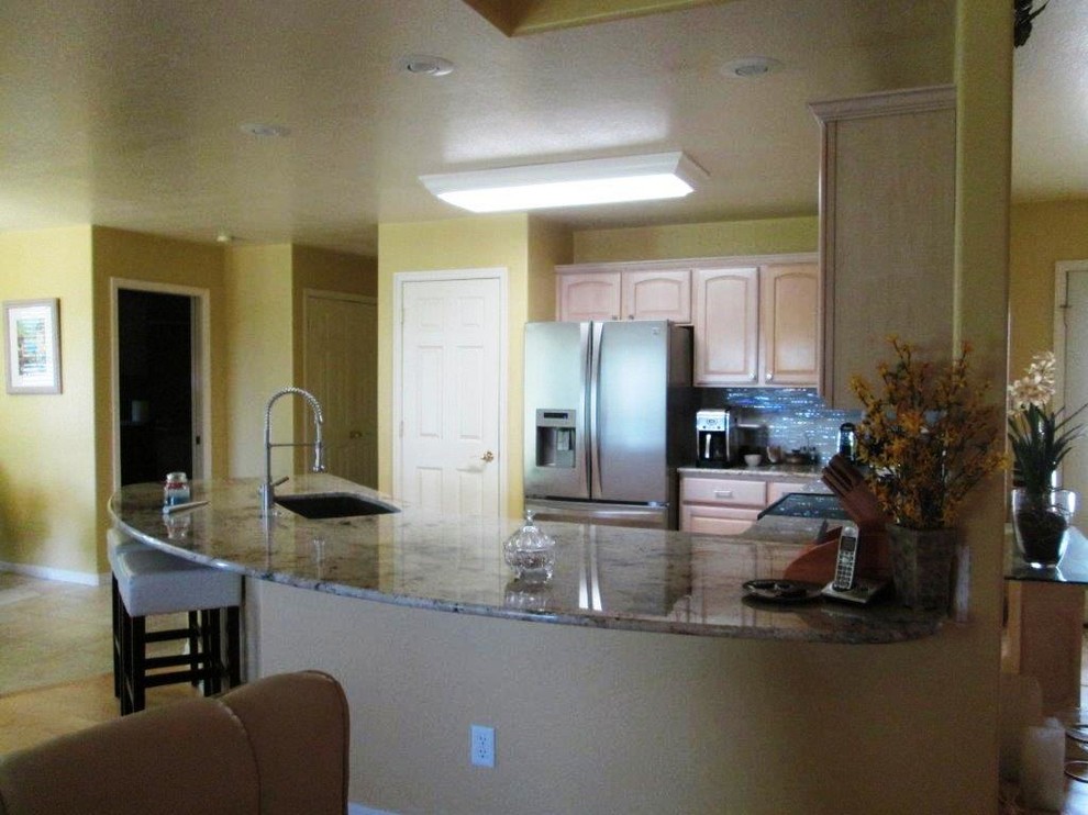 Bild på ett funkis kök, med en enkel diskho, granitbänkskiva, stänkskydd i glaskakel och en köksö