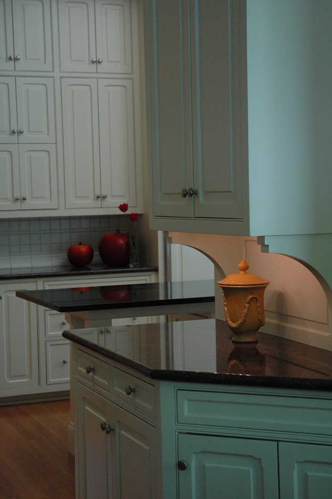 Immagine di una grande cucina moderna con ante con bugna sagomata, ante bianche, top in granito, paraspruzzi bianco, paraspruzzi con piastrelle in ceramica e pavimento in legno massello medio