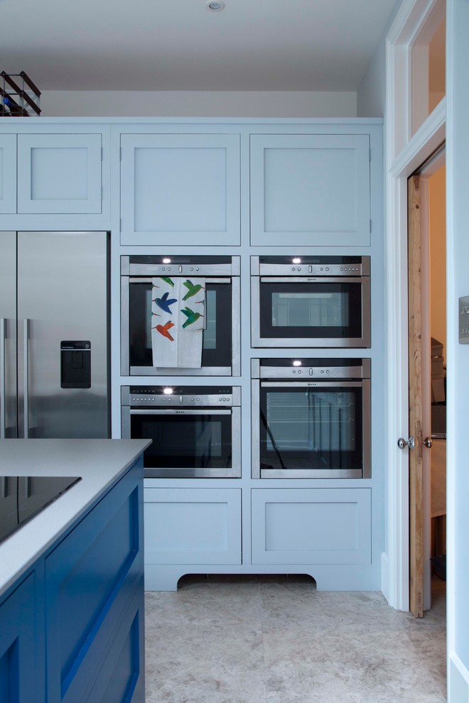 Exemple d'une cuisine tendance avec des portes de placard bleues et îlot.