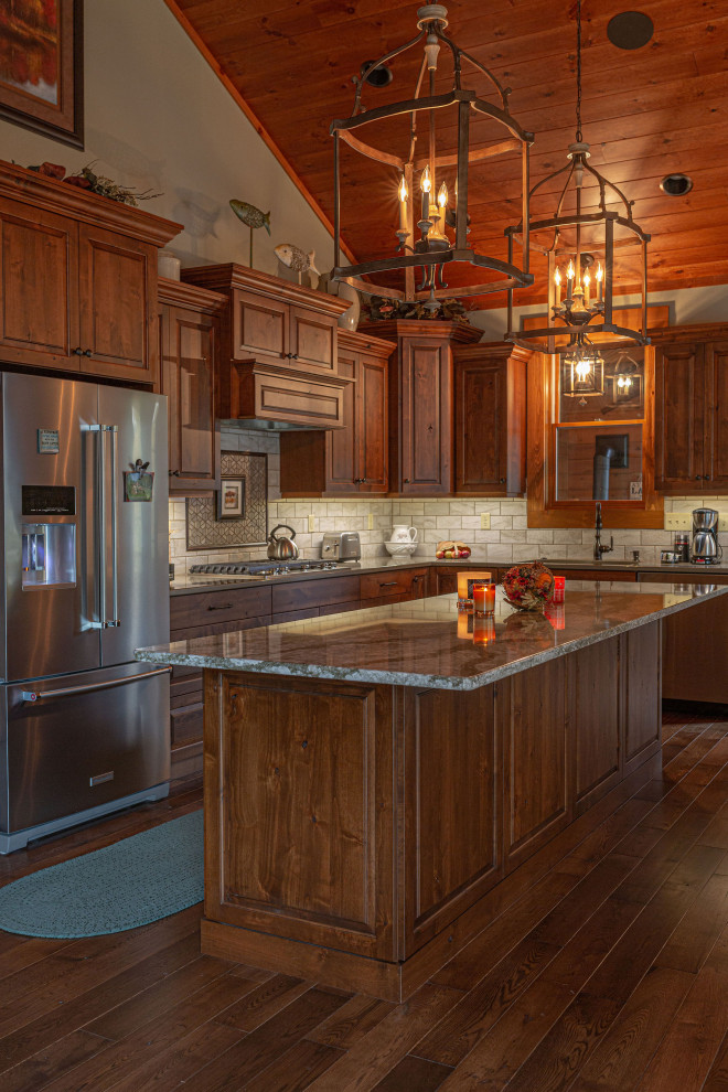 Foto på ett rustikt kök, med en nedsänkt diskho, luckor med upphöjd panel, skåp i mellenmörkt trä, bänkskiva i koppar, beige stänkskydd, stänkskydd i stenkakel, rostfria vitvaror, mellanmörkt trägolv och en köksö