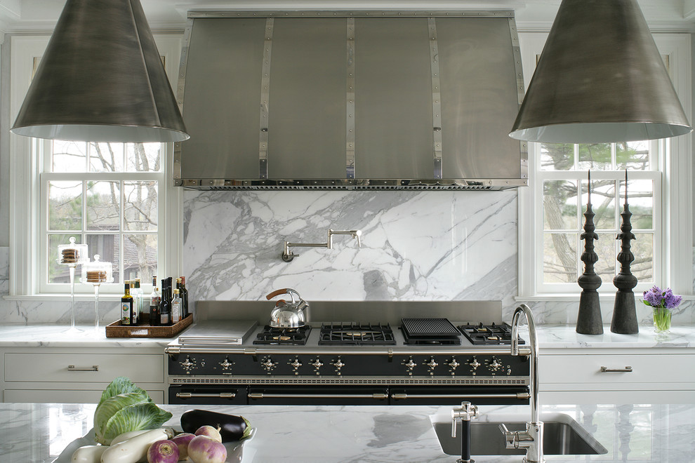 Foto på ett avskilt, stort vintage kök, med en undermonterad diskho, släta luckor, vita skåp, marmorbänkskiva, vitt stänkskydd, stänkskydd i marmor, svarta vitvaror, mörkt trägolv, en köksö och brunt golv