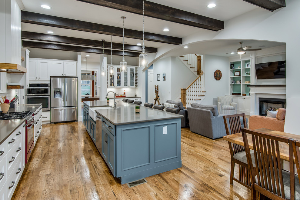 Design ideas for a large classic l-shaped open plan kitchen in Nashville with recessed-panel cabinets, blue cabinets, quartz worktops, green splashback, stone tiled splashback, stainless steel appliances, medium hardwood flooring and an island.