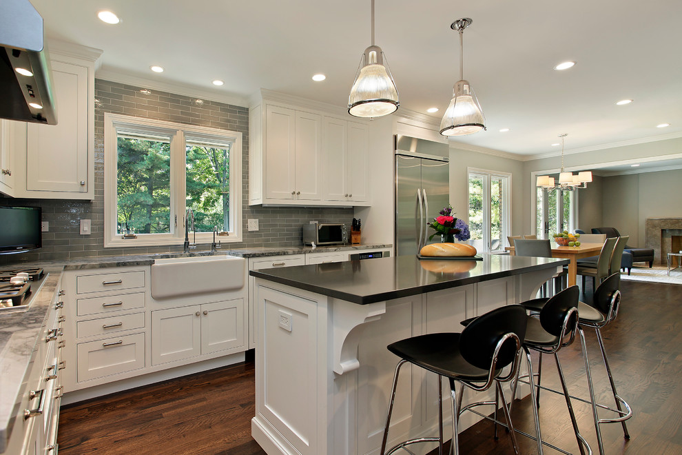 Elegant kitchen photo in Chicago with subway tile backsplash, a farmhouse sink and stainless steel appliances