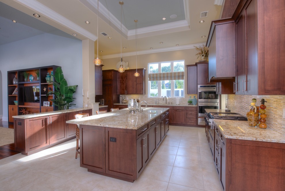 Klassische Küche mit Schrankfronten im Shaker-Stil, dunklen Holzschränken, Granit-Arbeitsplatte, Küchenrückwand in Beige und Küchengeräten aus Edelstahl in Tampa