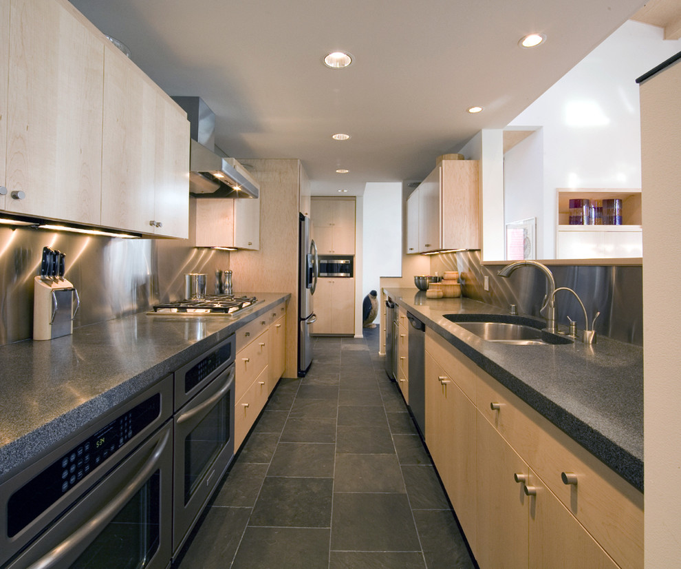 Idéer för att renovera ett funkis kök, med stänkskydd i metallkakel, en undermonterad diskho, släta luckor, skåp i ljust trä, granitbänkskiva, stänkskydd med metallisk yta, rostfria vitvaror och grått golv