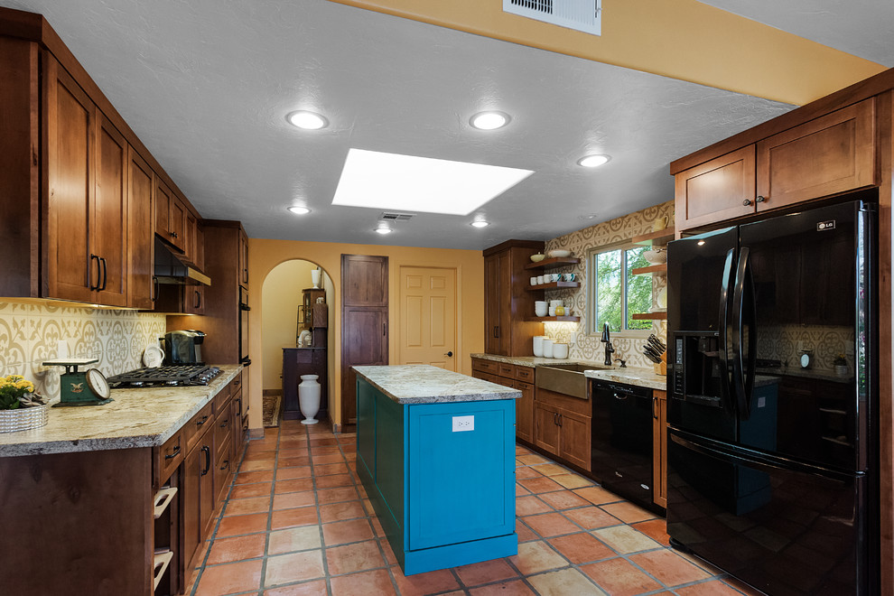 Mid-sized transitional u-shaped terra-cotta tile and red floor eat-in kitchen photo in Phoenix with a drop-in sink, flat-panel cabinets, brown cabinets, granite countertops, beige backsplash, porcelain backsplash, black appliances, an island and beige countertops