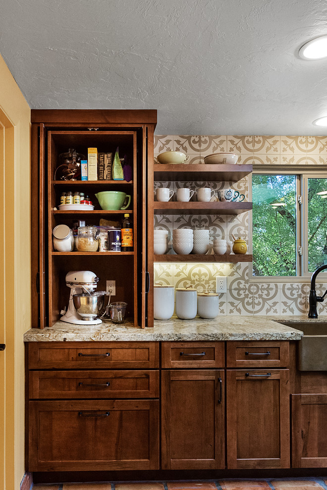 Exempel på ett mellanstort klassiskt beige beige kök, med en nedsänkt diskho, släta luckor, bruna skåp, granitbänkskiva, beige stänkskydd, stänkskydd i porslinskakel, svarta vitvaror, klinkergolv i terrakotta, en köksö och rött golv