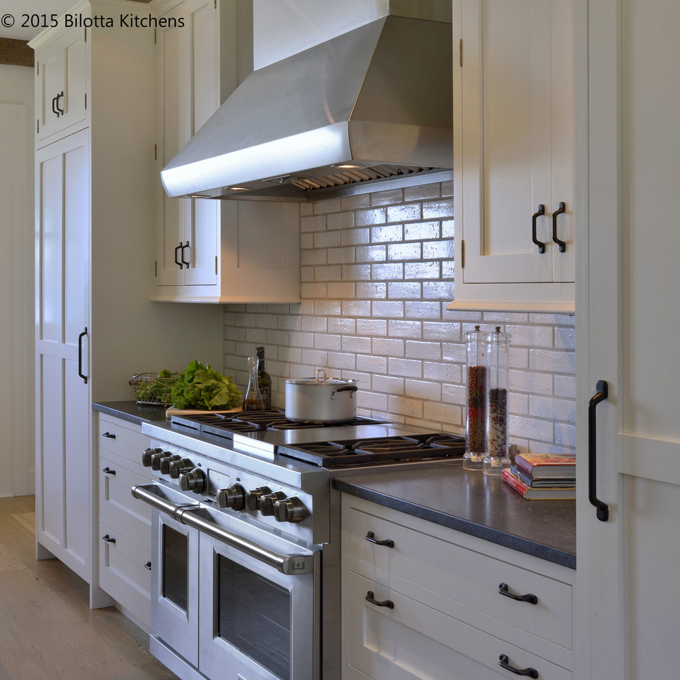Exempel på ett mycket stort klassiskt kök med öppen planlösning, med en undermonterad diskho, skåp i shakerstil, skåp i ljust trä, granitbänkskiva, vitt stänkskydd, integrerade vitvaror, ljust trägolv och en köksö