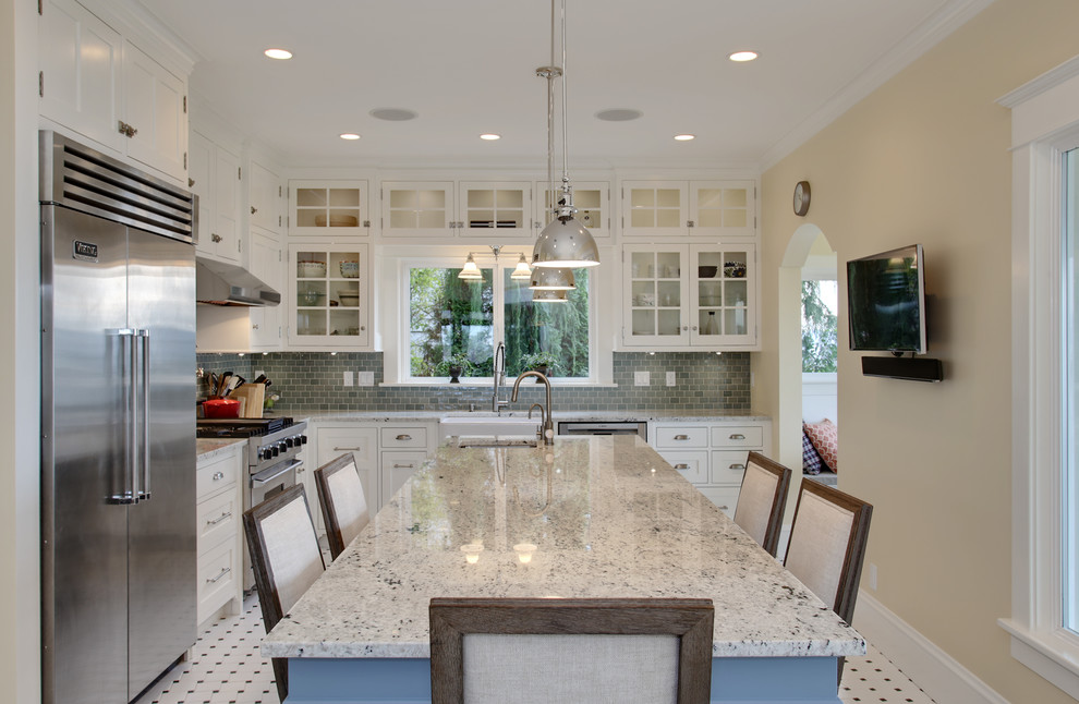 Large arts and crafts ceramic tile eat-in kitchen photo in Seattle with a farmhouse sink, recessed-panel cabinets, white cabinets, granite countertops, blue backsplash, glass tile backsplash, stainless steel appliances and an island