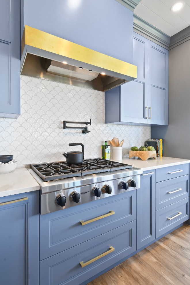 Foto på ett mellanstort maritimt vit kök, med en rustik diskho, skåp i shakerstil, blå skåp, bänkskiva i kvarts, vitt stänkskydd, stänkskydd i porslinskakel, svarta vitvaror, klinkergolv i porslin, en köksö och brunt golv