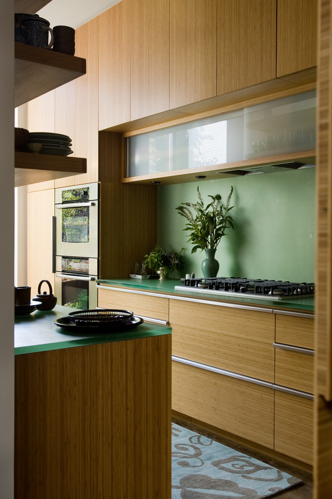 Trendy galley kitchen photo in Birmingham with flat-panel cabinets, light wood cabinets and stainless steel appliances