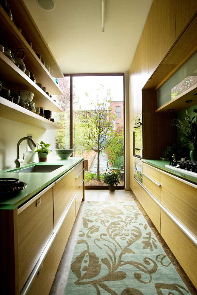 Modelo de cocina actual cerrada con fregadero bajoencimera, armarios abiertos, puertas de armario de madera clara y encimeras verdes